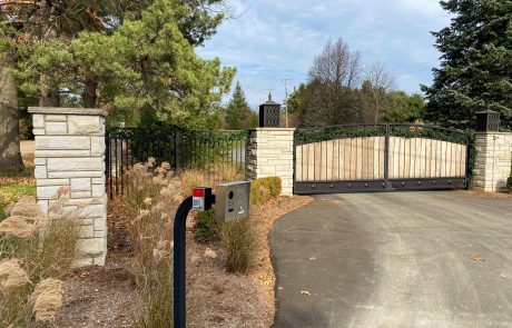 Black sliding gate operator outside a black swinging gate