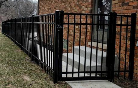 Residential Aluminum and Steel black fencing with a gate near stairs of a home