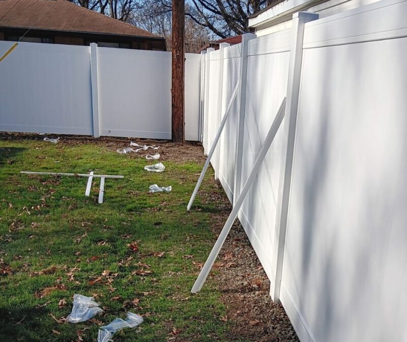 White residential vinyl fence installation by Anchor Fence, featuring tools and materials used for a professional, durable, and low-maintenance fencing solution for homes.