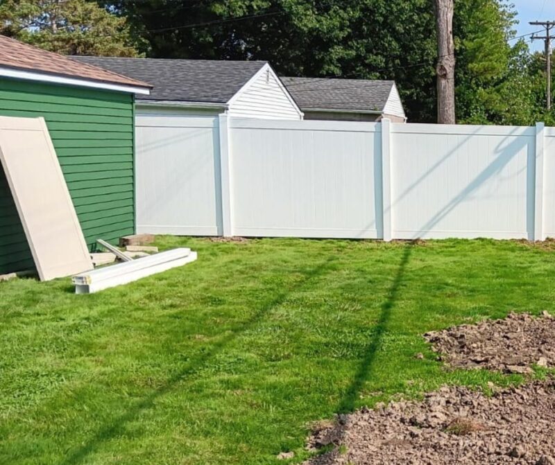 White vinyl fence installation in progress by Anchor Fence, featuring fencing supplies and tools for a professional, durable, and low-maintenance residential fencing solution.