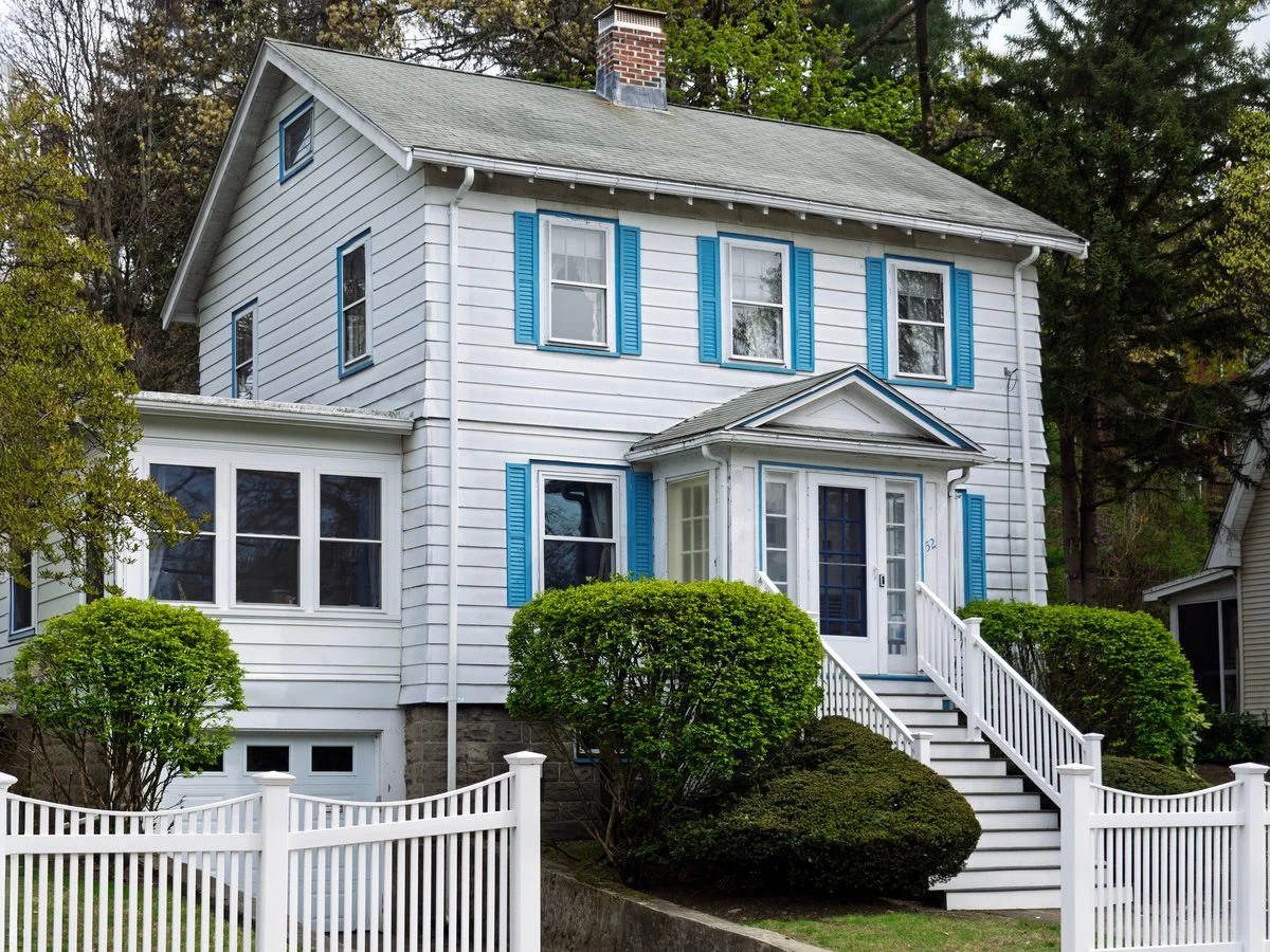 White vinyl picket fence in front of a suburban home